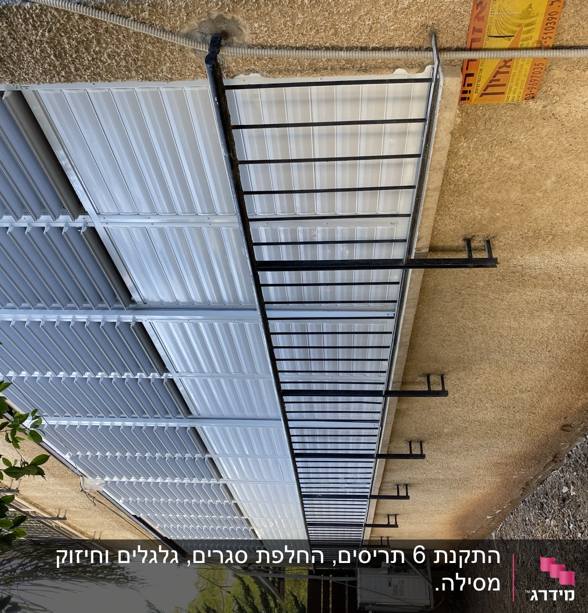 תריסים לבנים מותקנים על קיר חיצוני עם מסגרת מתכת.